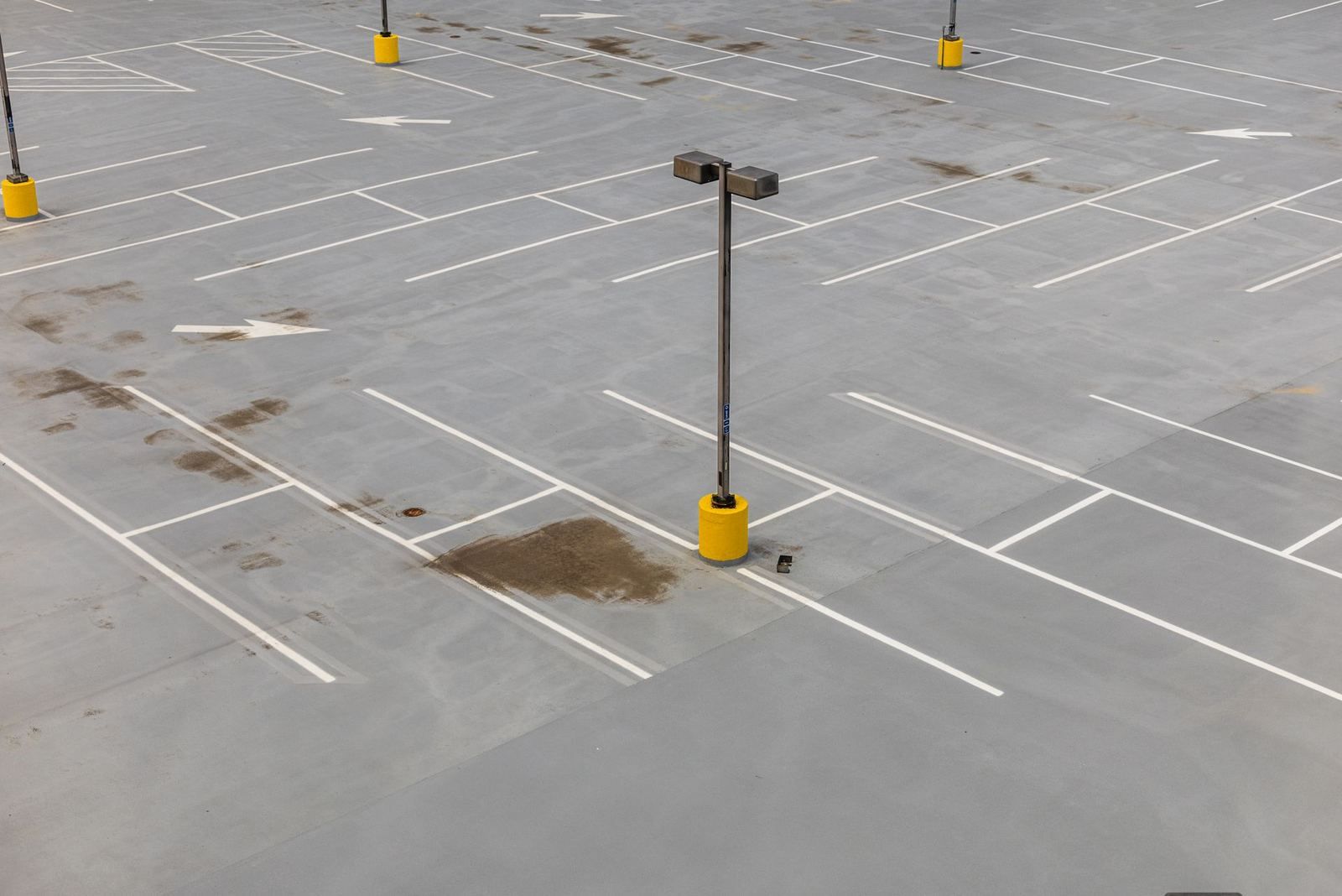 Empty concrete parking lot with light poles (stock photo)